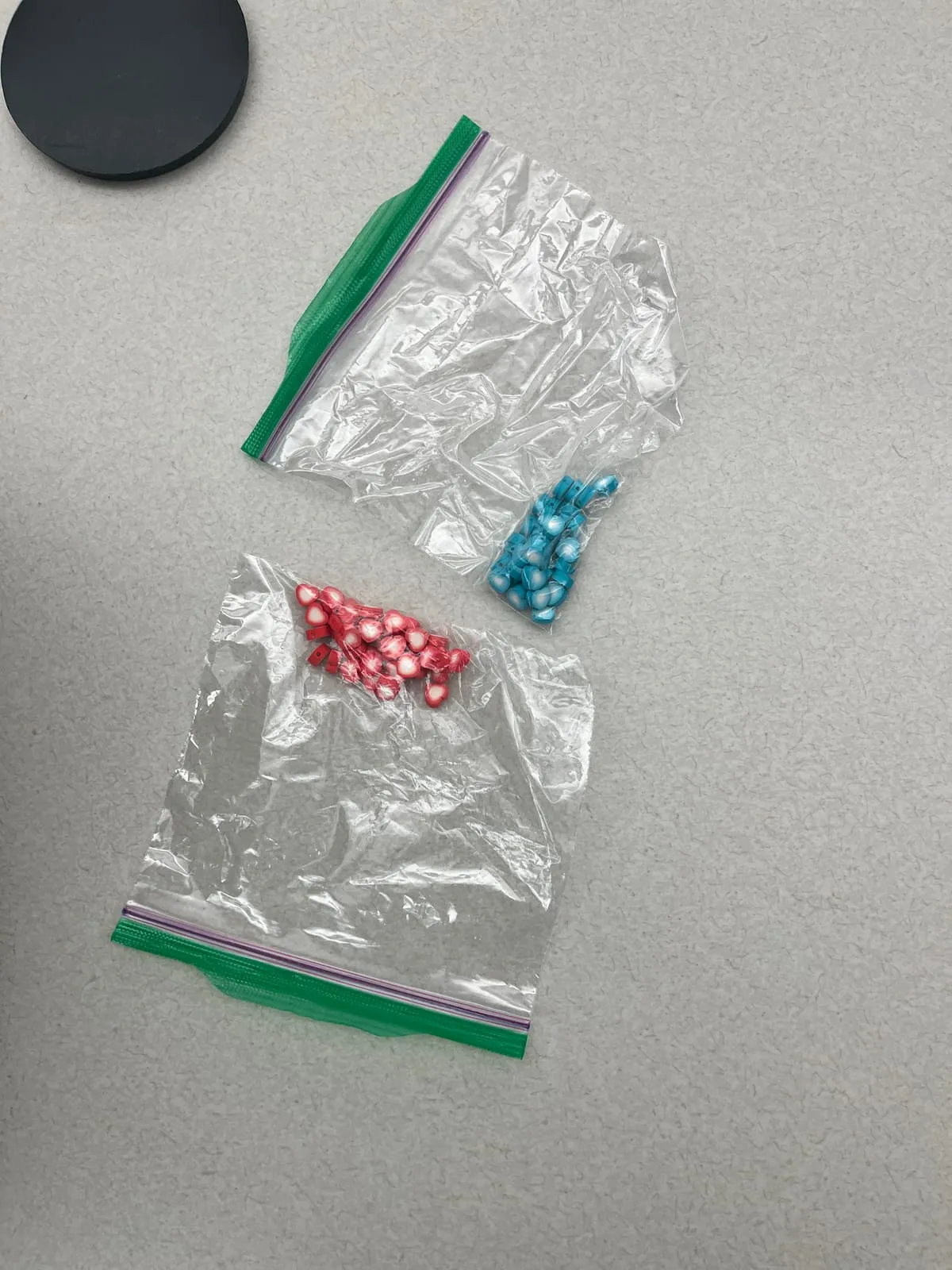 Two small bags of red and blue heart-shaped counters