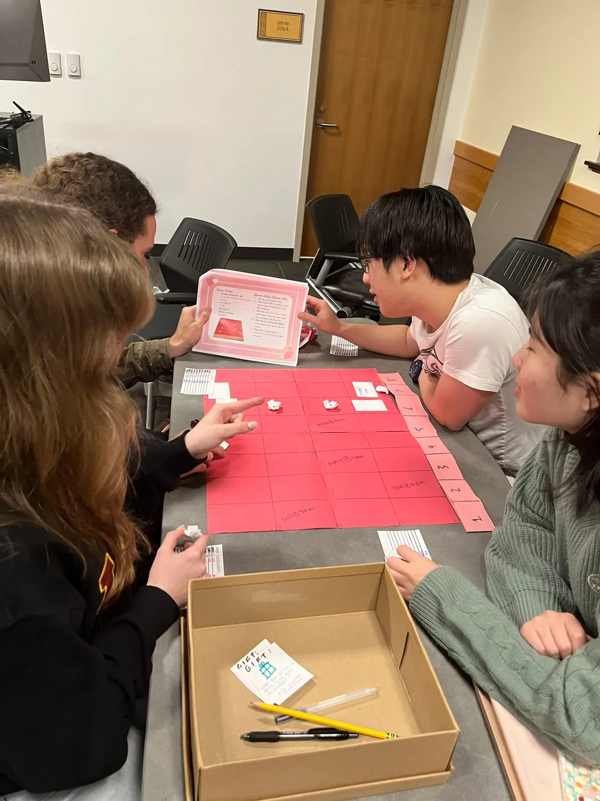 Players around the red paper board during the public playtest